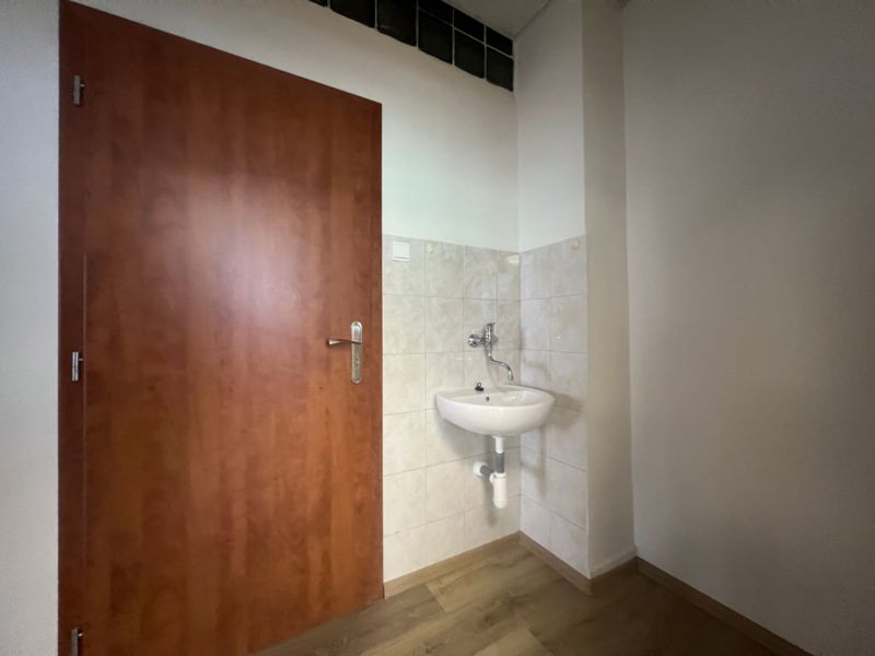 Offices with a sink, doors, and a floor with a wood design.