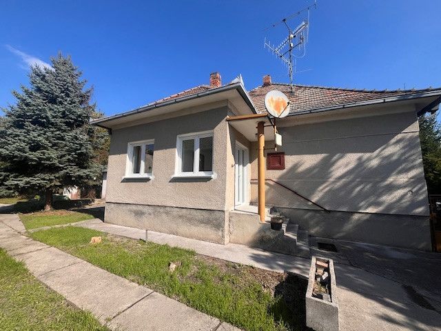 A family house in Vrakúň with a lawn, satellite, and antenna on the roof.