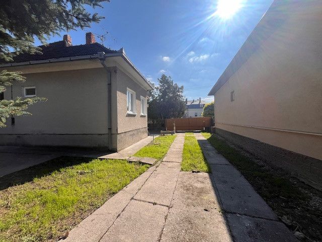 A family house in Vrakúňa with a concrete walkway and a grassy area.