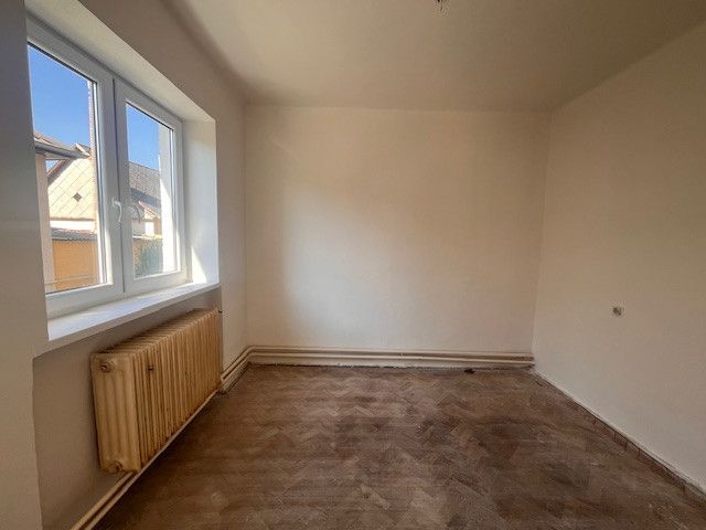 A room in a family house with a window and a floor with a wooden decor.