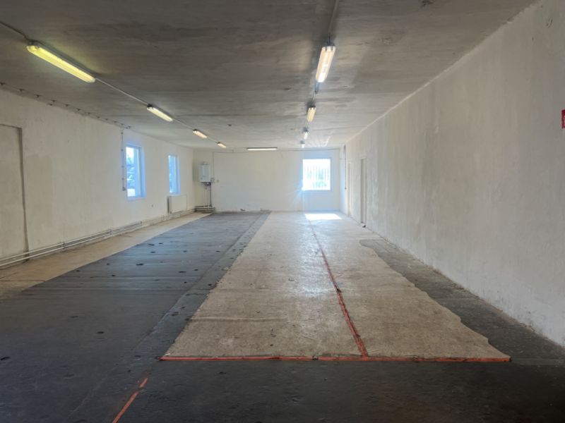Empty interior room in warehouses and halls with concrete flooring and lighting.