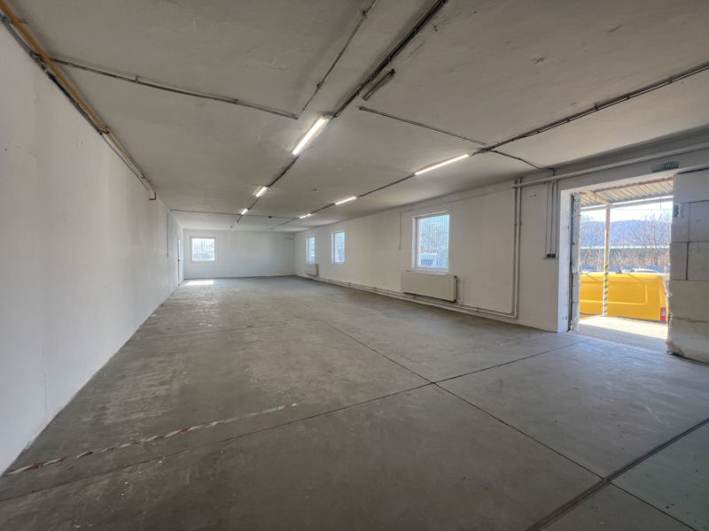 Spacious interior of warehouses and halls with concrete flooring and plenty of natural light.