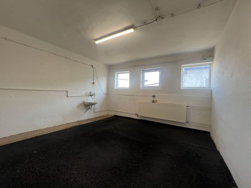 Empty room in warehouses and halls with windows, a sink, and a radiator.