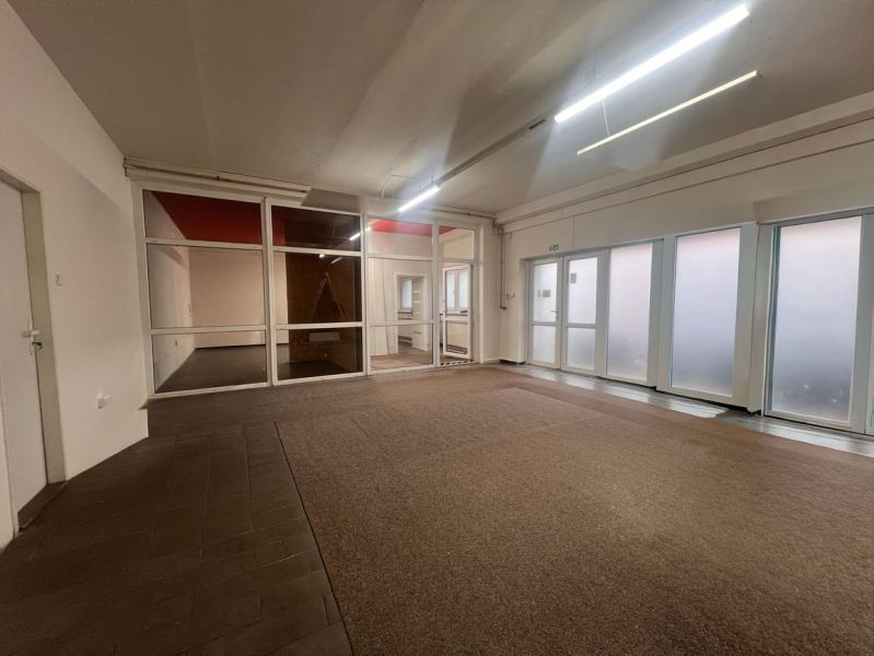 Commercial spaces with glass partitions and carpet flooring.