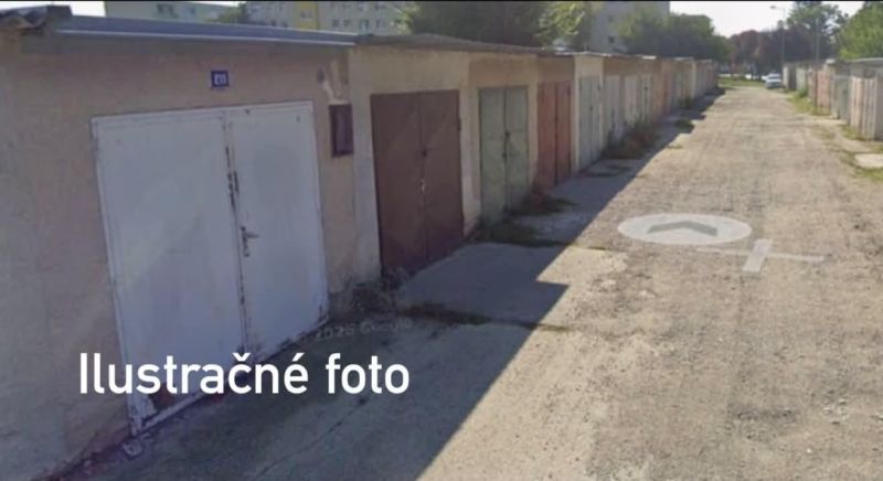 A row of garages in Dunajská Streda with different colored doors on a paved road.