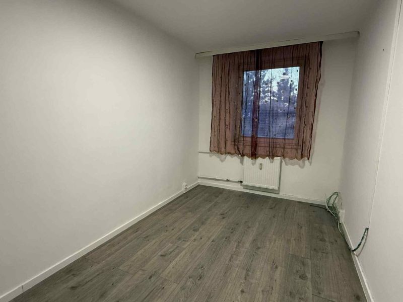 A room in a 4-room apartment with a wooden decor floor and a simple curtain.