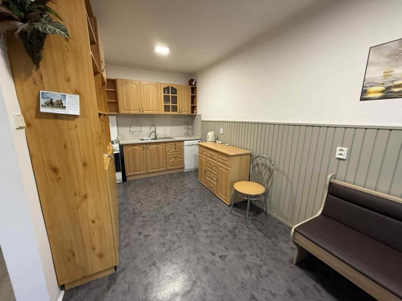 A kitchen in a 4-room apartment with wooden cabinets and a floor with a wooden decor.
