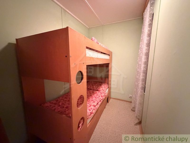 Bunk bed in a cottage, bright room with soft lighting.