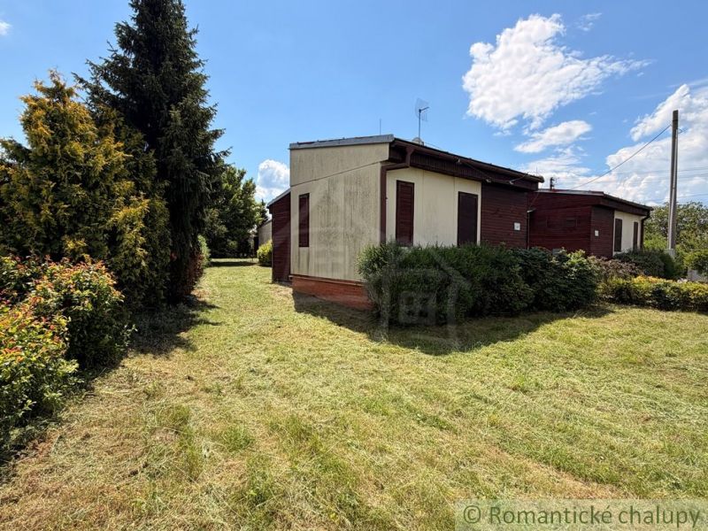 A cottage in Nové Zámky with a garden and a sky full of clouds.