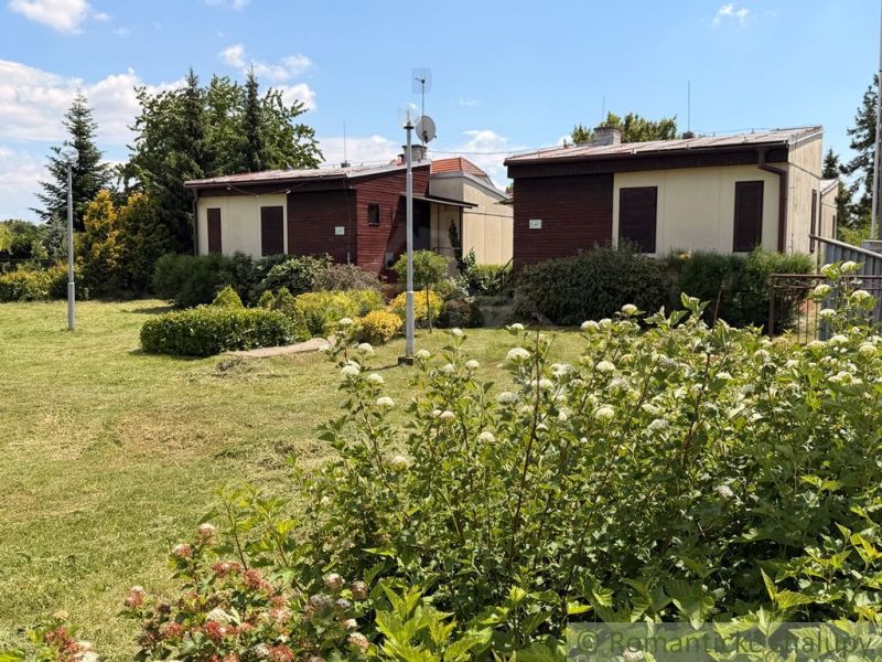 Two cottages in Nové Zámky surrounded by a landscaped garden and greenery.