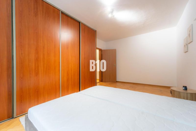 Bedroom with a large wardrobe in a two-room apartment, floor with wood decor.