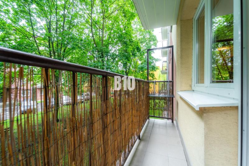 A balcony in a 2-room apartment with a view of greenery, surrounded by trees in the city of Martin.