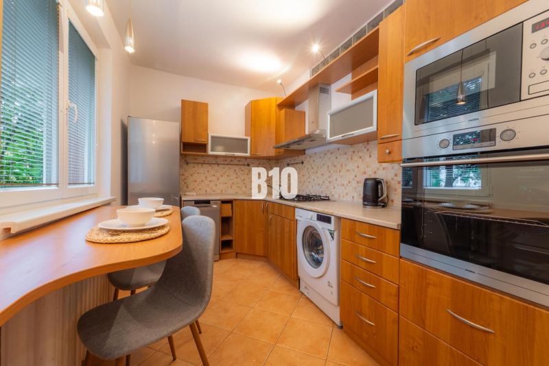 A kitchen in a 2-room apartment with a wooden decor and appliances.