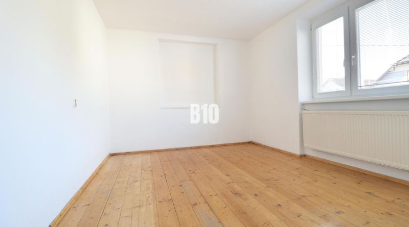 An empty room with a wooden decor floor in a family house.
