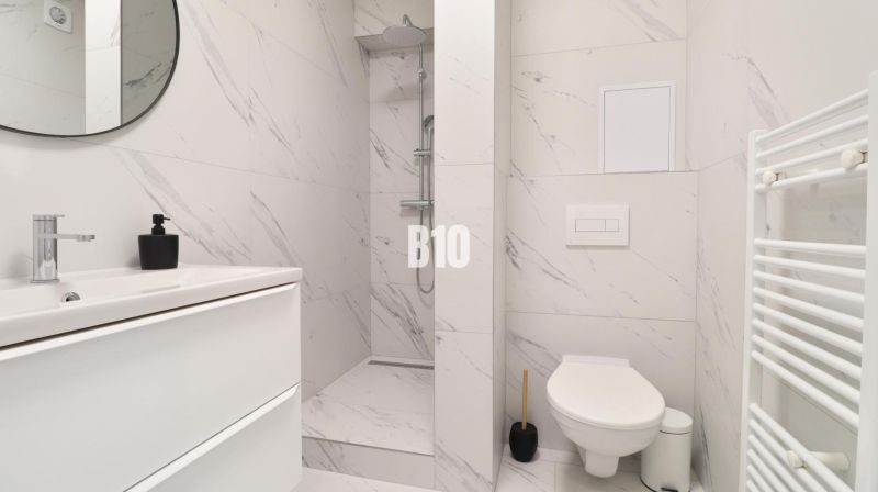 A bathroom in a 2-room apartment with a modern shower and white sanitary ware.