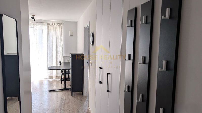 A hallway in a 2-room apartment with a wooden decor floor and curtains.