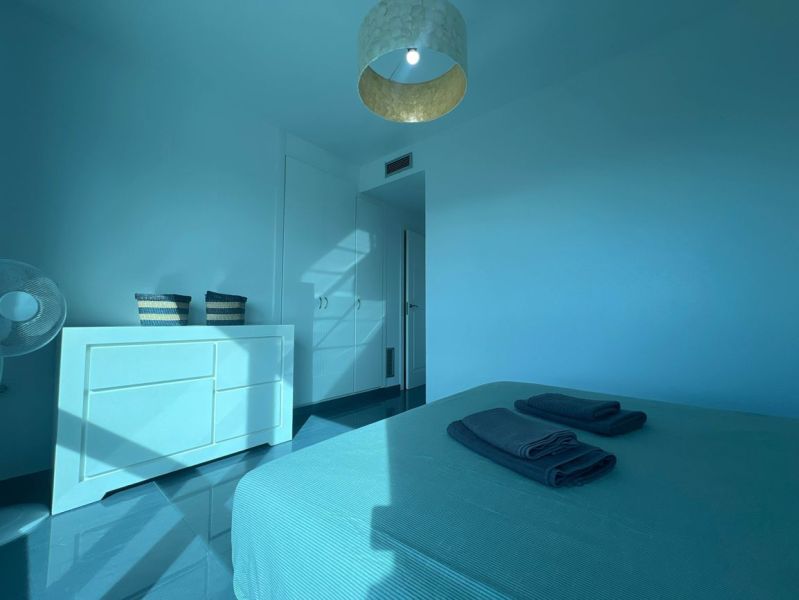 Recreational apartment with a bright room, bed, dresser, and balcony in blue tones.