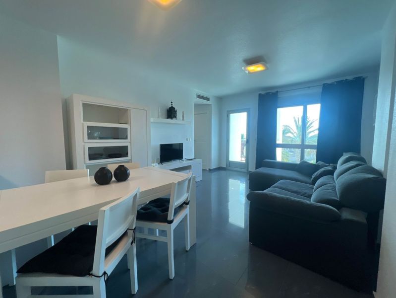 Dining table with chairs and a sofa, holiday apartment, floor with wooden decor.