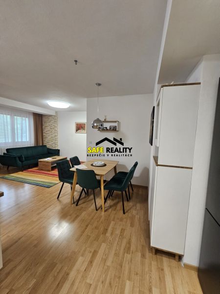 Dining room in a 3-room apartment with a wood-patterned floor and a sofa.