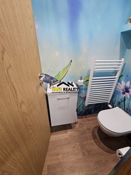 A bathroom with a natural motif and a wooden decor floor in a 3-room apartment.