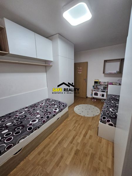 Children's room with wood decor flooring and built-in wardrobes in a 3-room apartment.