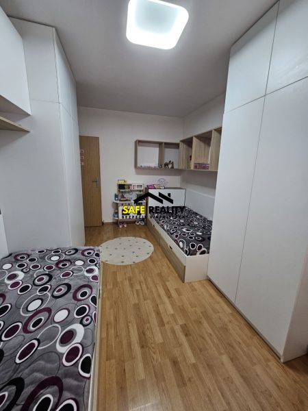 Children's room with beds and wooden decor flooring in a 3-room apartment.