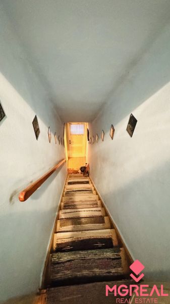 A narrow staircase with walls decorated with paintings in a 3-room apartment.