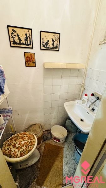 A small bathroom with a sink and decorations in a 3-room apartment.