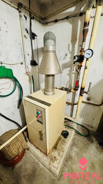 Heating in the utility room of a 3-bedroom apartment with wiring and piping on the walls.