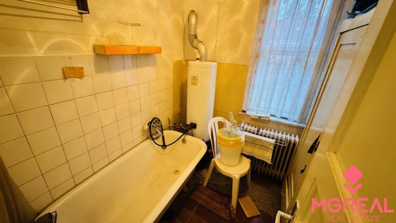 A bathroom with a bathtub and a boiler in a 3-room apartment.