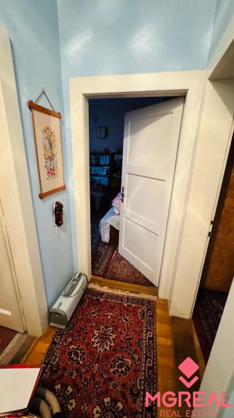 A room in a 3-bedroom apartment with a carpet and open doors, floor with wood decor.