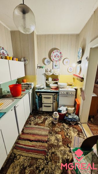A kitchen with vintage decor in a 3-room apartment and a carpet with a colorful pattern.