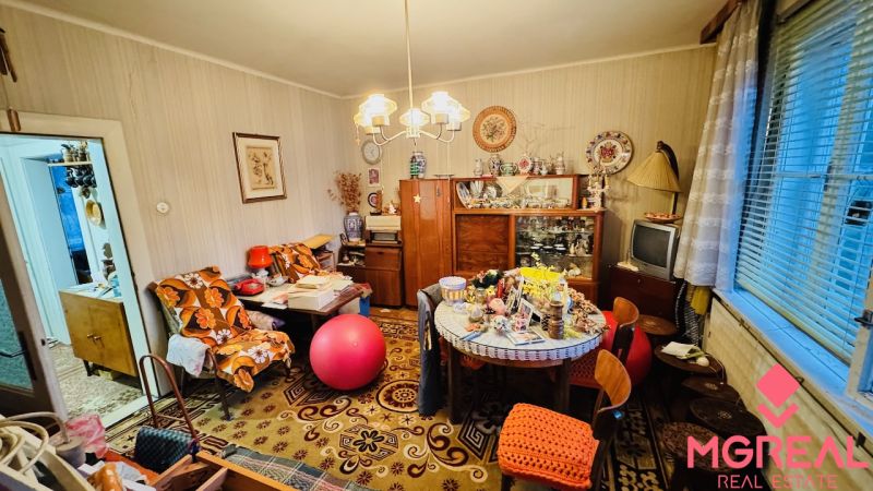 A room full of vintage furniture and decorations in a 3-room apartment with a wood-patterned floor.