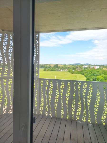 A balcony with a panoramic view and a wooden decor floor in a 2-room apartment.