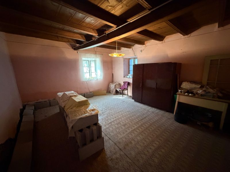 A room in a family house with furniture, stacks of bricks, and a wooden ceiling.