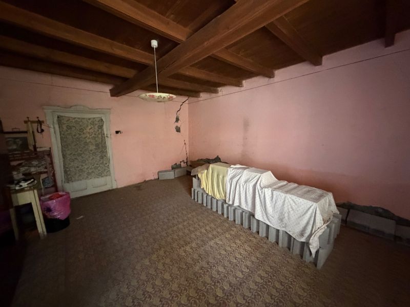 A room in a family house with antique lighting and a beamed ceiling.
