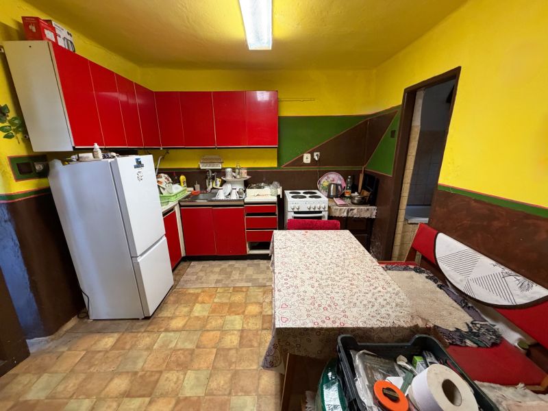 A family house with a kitchen, red cabinets, and white appliances.