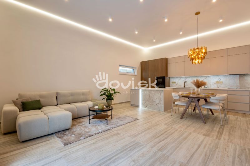 Interior of a family house with an open kitchen, a sofa set, and a wooden decor floor.