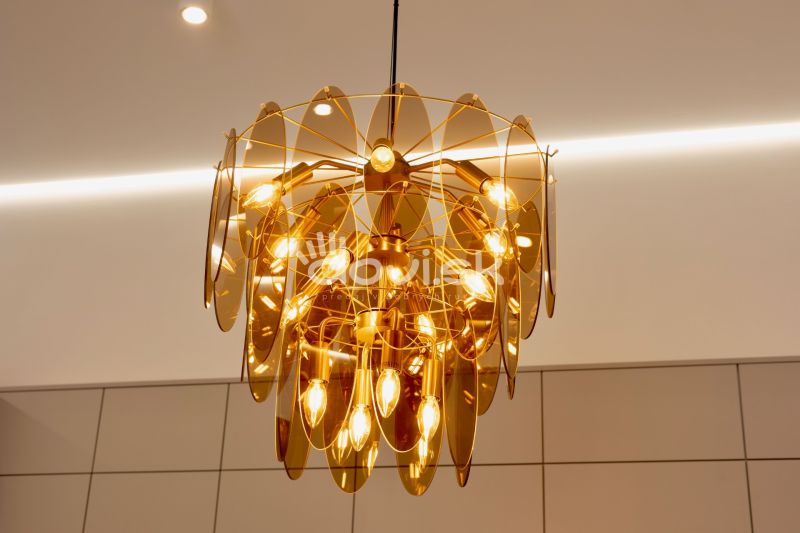 A golden chandelier in the interior of a family house adorns the room with its unique design.