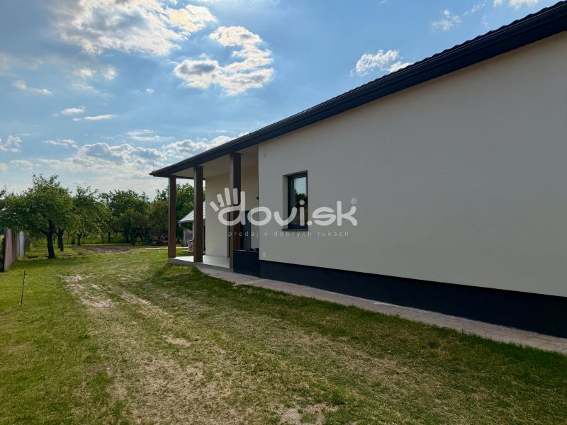 The exterior of a family house in Zemplínska Široká surrounded by lawn and trees.