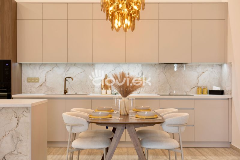 Kitchen area with dining table, beige cabinets, wood-patterned floor, light fixture.