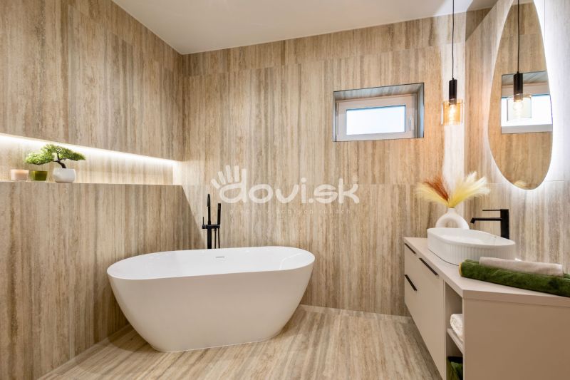 A bathroom in a family house with a freestanding bathtub, wooden decor, and pendant lighting.