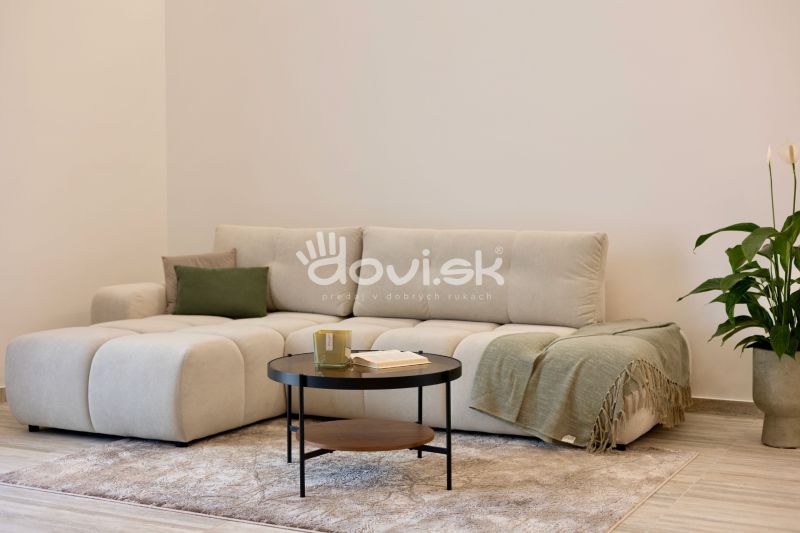 A bright interior with a comfortable sofa, a coffee table, and a wooden decor floor.