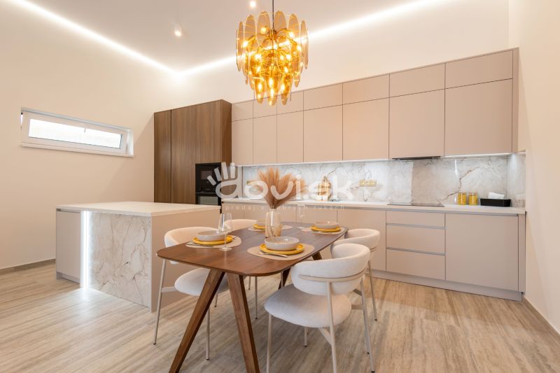 Dining room in a family house with marble decor on the walls and a wooden table.