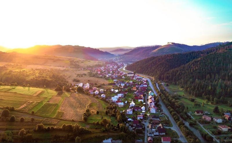 The landscape around Nová Bystrica with agricultural and forest lands at sunset.