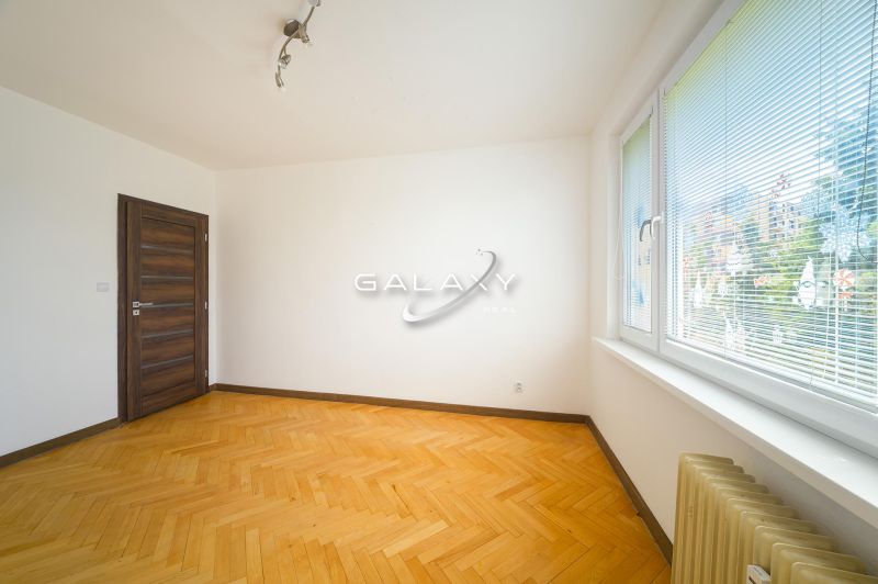 A room in a 3-room apartment with a wood-patterned floor and large windows.