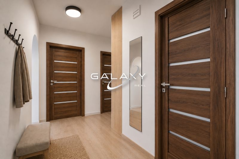 A hallway with a wood-patterned floor, a mirror, and Scandinavian furniture in a three-room apartment.