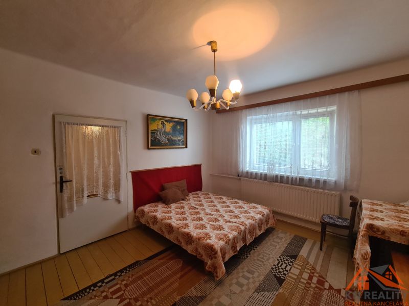 Bedroom in a family house with a decorative chandelier, curtains, and carpet.
