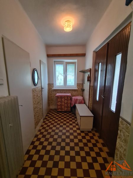 A hallway with tiles in a family house, light source, storage space, radiator.