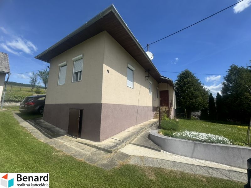 A family house in Orlov with a driveway, a car, and a landscaped garden.